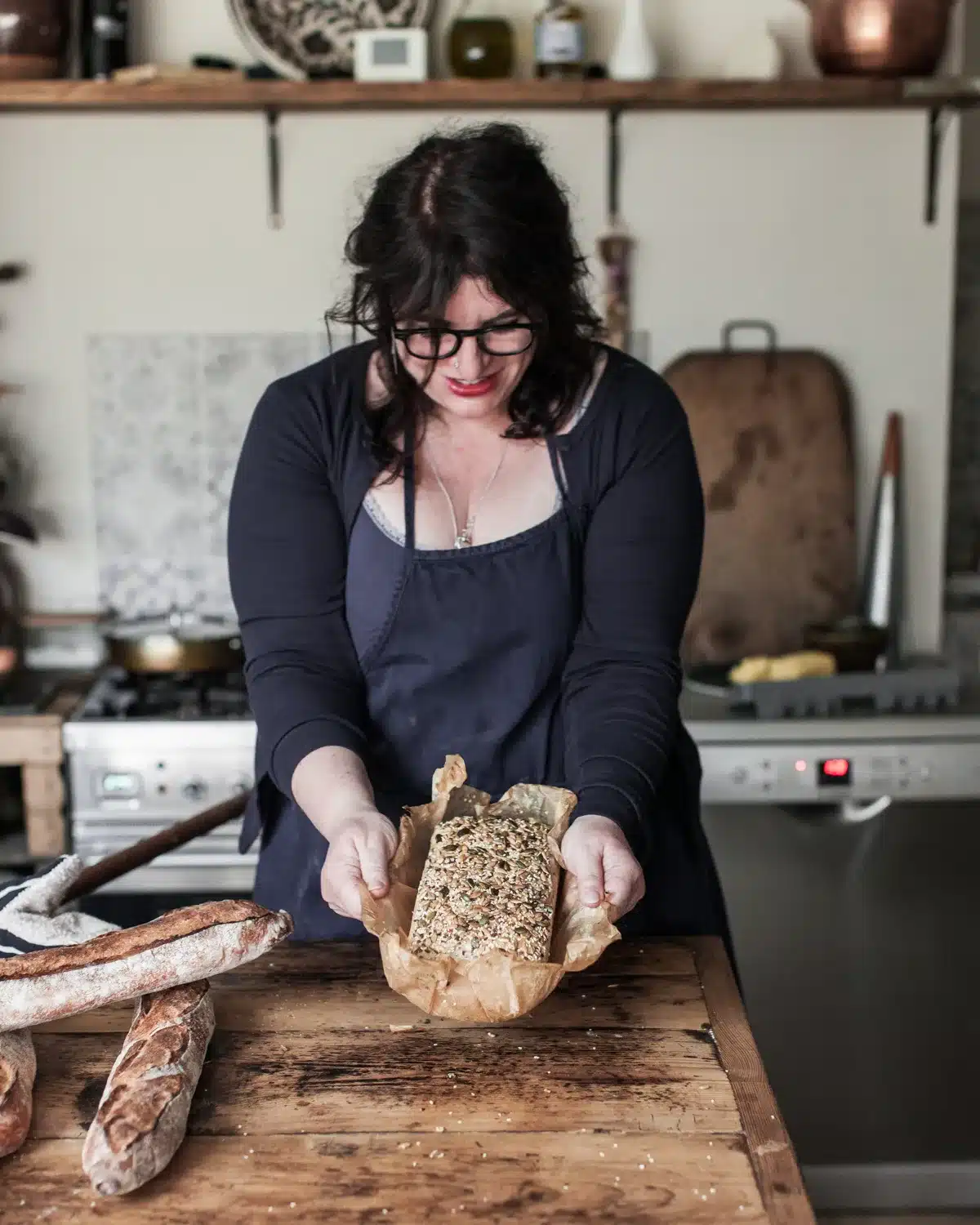Seeded sourdough loaf, sliced, Vanessa holding